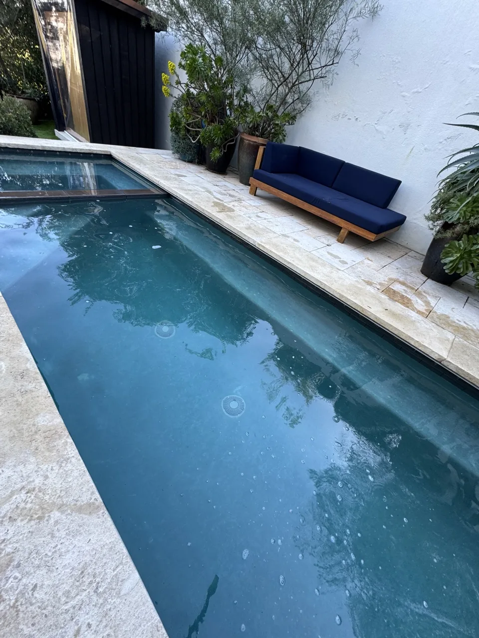 Matching courtyard pool with blue water and a raised square spa