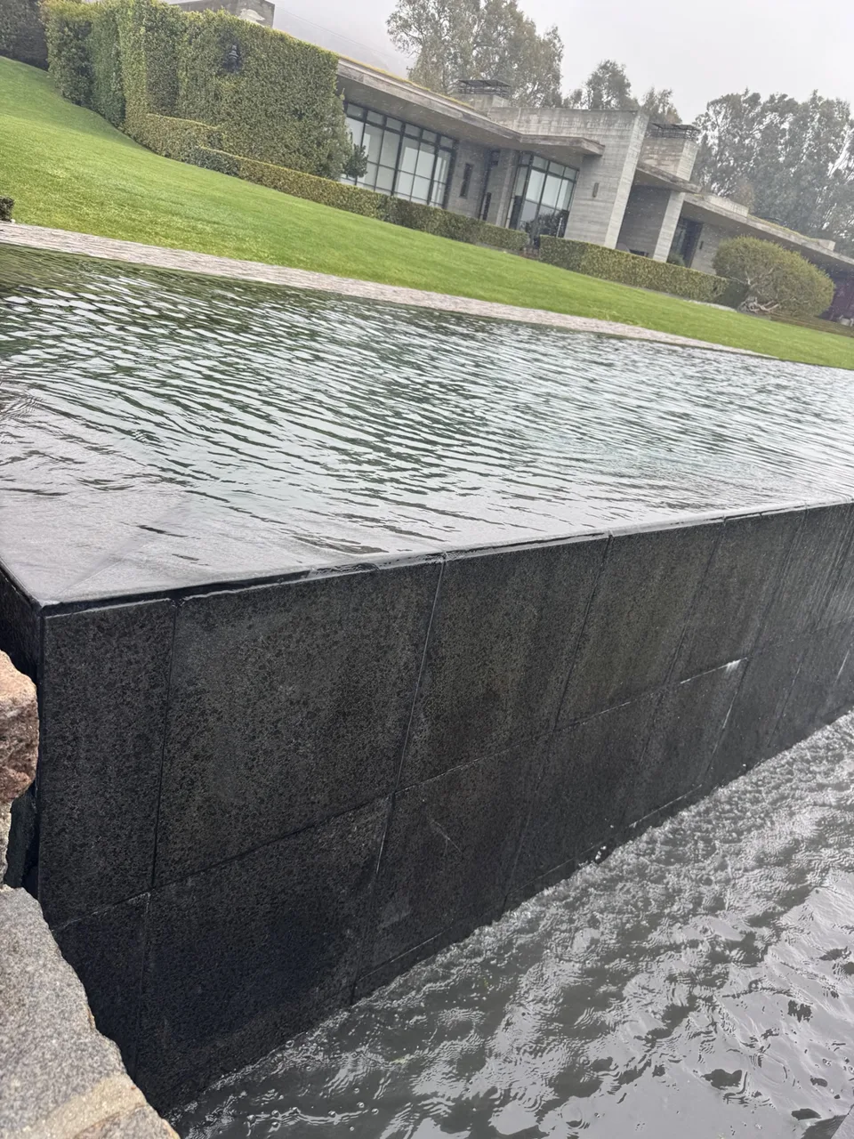 Close view of an infinity pool edge and catch basin